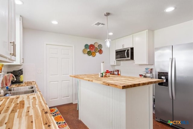 17179 Cyclone Rd, Burlington, TX 76519 - kitchen featuring butcher block countertops, appliances with stainless steel finishes, tasteful backsplash, white cabinets, and recessed lighting