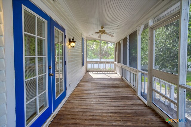 unfurnished sunroom with ceiling fan and plenty of natural light