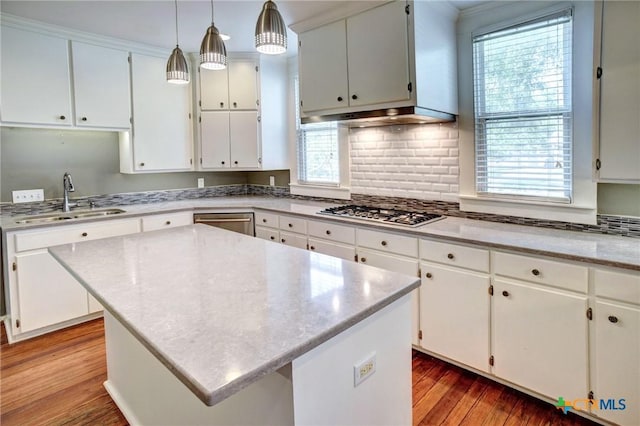 1322 N Ave F Ave, Shiner, TX 77984 - kitchen with stainless steel gas cooktop, a sink, light wood-style flooring, white cabinetry, and backsplash
