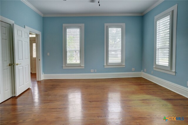 unfurnished room with hardwood / wood-style floors, ceiling fan, and crown molding