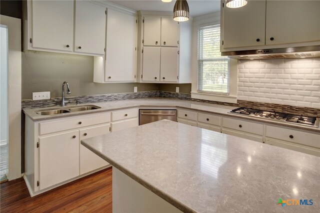 kitchen featuring white cabinetry, sink, appliances with stainless steel finishes, decorative light fixtures, and dark hardwood / wood-style flooring