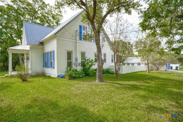 1322 N Ave F Ave, Shiner, TX 77984 - view of property exterior with a yard and metal roof