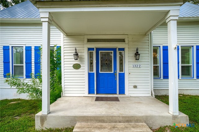 view of exterior entry featuring a porch