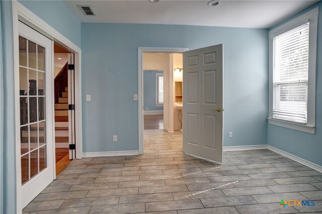 empty room with french doors and light hardwood / wood-style flooring