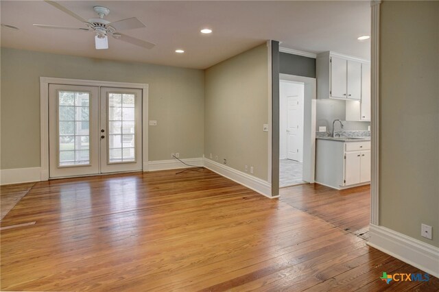 interior space with ceiling fan, sink, light hardwood / wood-style flooring, and french doors