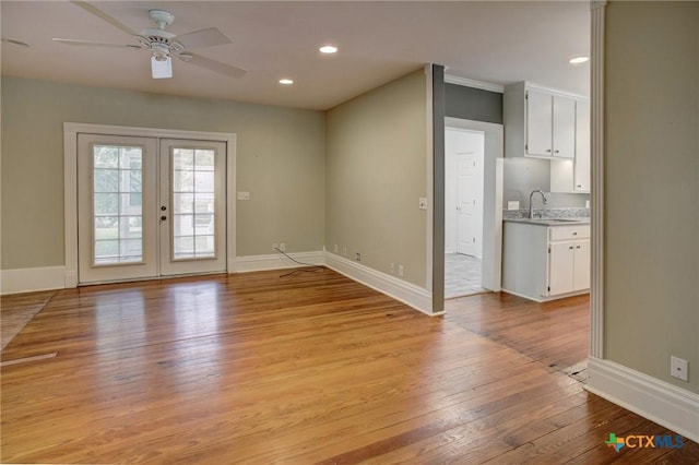 1322 N Ave F Ave, Shiner, TX 77984 - interior space with light wood-type flooring, a sink, french doors, a ceiling fan, and baseboards