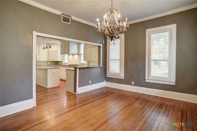 interior space with hardwood / wood-style flooring, crown molding, and an inviting chandelier