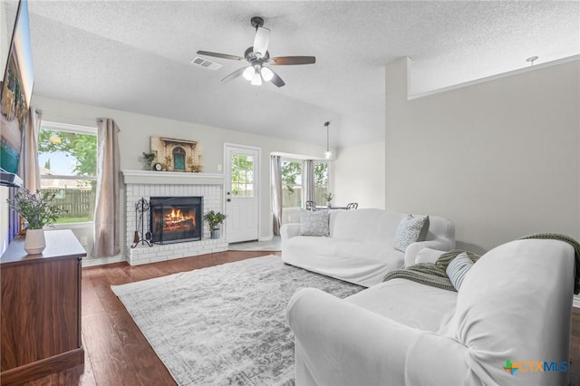 2804 Bluejay Dr, Killeen, TX 76549 - living area with a textured ceiling, lofted ceiling, a fireplace, ceiling fan, and dark wood-style floors
