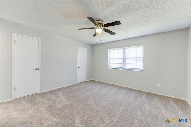 carpeted spare room featuring a textured ceiling and ceiling fan