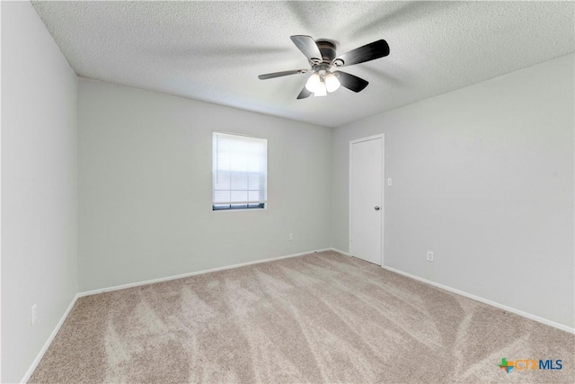 unfurnished room featuring baseboards, carpet floors, a textured ceiling, and ceiling fan