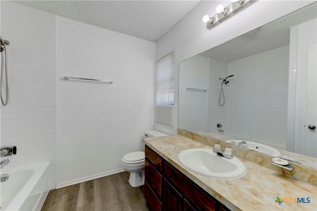 bathroom featuring toilet, bathing tub / shower combination, wood finished floors, a textured ceiling, and vanity