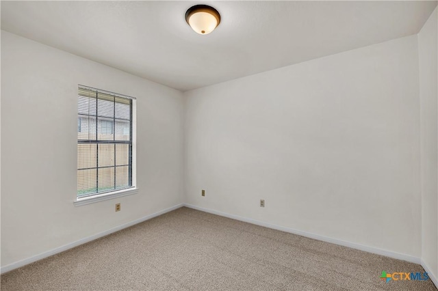 empty room with carpet floors and baseboards