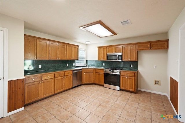 503 Pine St, Smithville, TX 78957 - kitchen featuring appliances with stainless steel finishes, brown cabinets, and tasteful backsplash