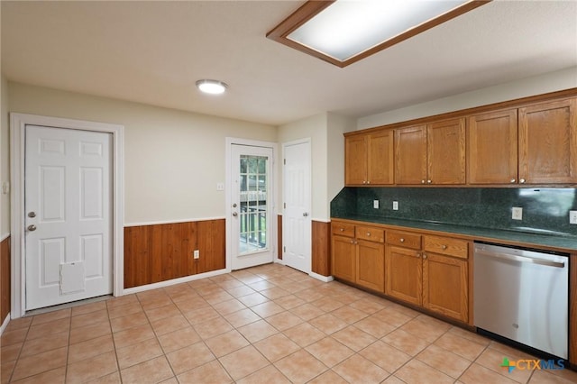 503 Pine St, Smithville, TX 78957 - kitchen featuring dishwasher, brown cabinetry, a wainscoted wall, dark countertops, and wood walls