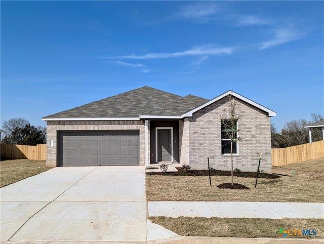 ranch-style house featuring a front lawn and a garage