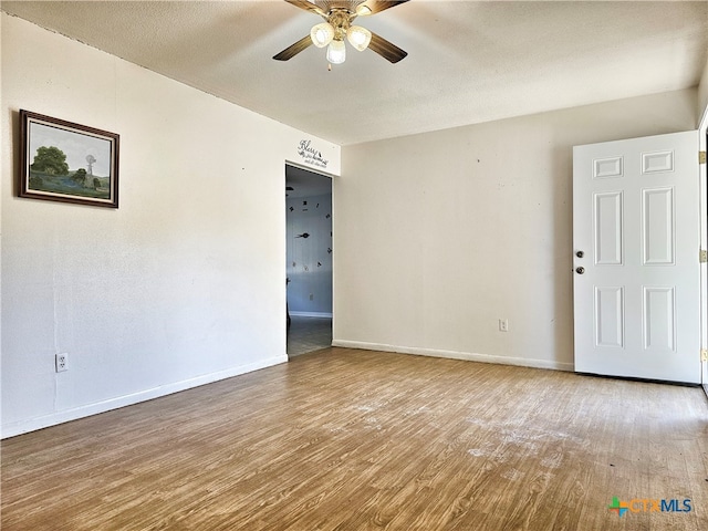 unfurnished room with ceiling fan, wood-type flooring, and a textured ceiling