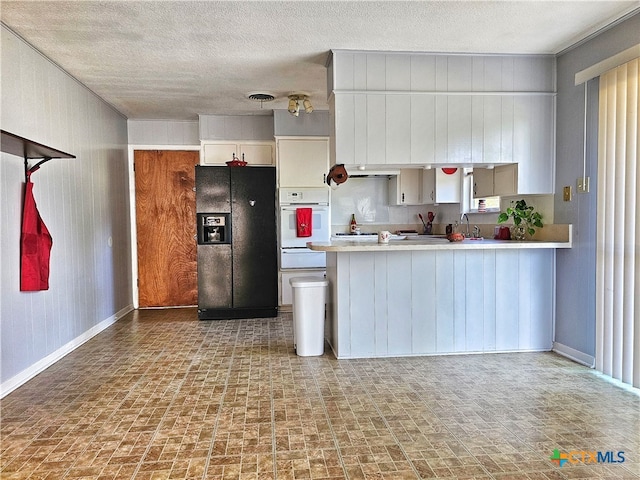 kitchen featuring black refrigerator with ice dispenser, white cabinetry, oven, and a textured ceiling