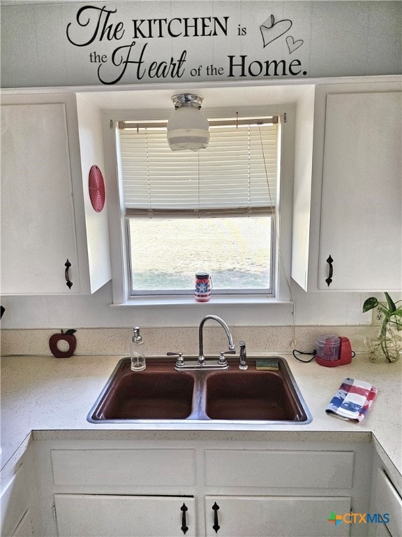 kitchen featuring white cabinetry, sink, and a healthy amount of sunlight