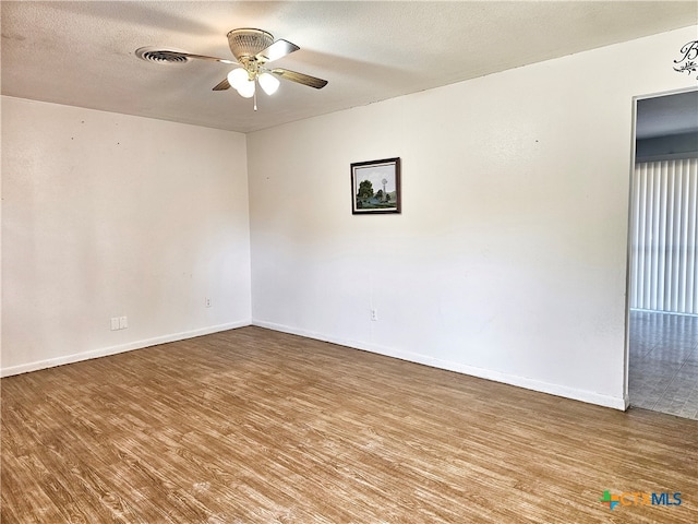 empty room with a textured ceiling, hardwood / wood-style flooring, and ceiling fan