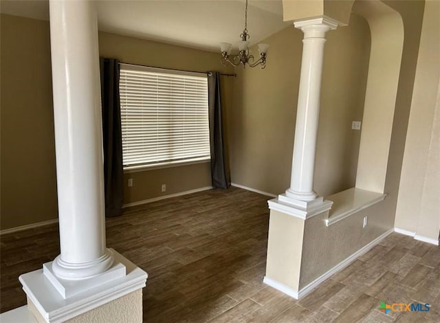 unfurnished living room with dark wood-type flooring and decorative columns