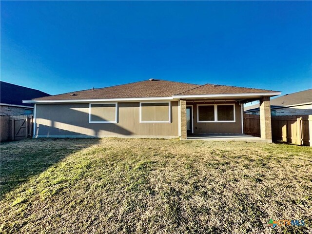 rear view of property featuring a patio area and a lawn