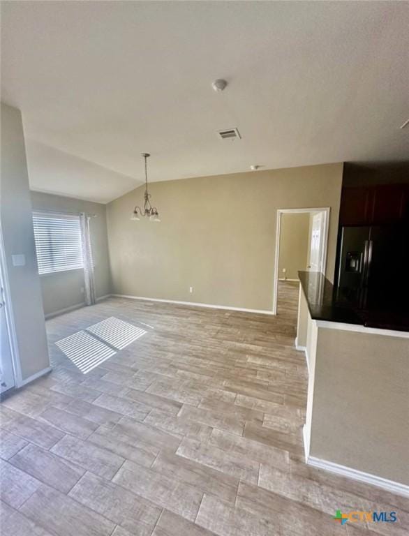 unfurnished room with an inviting chandelier