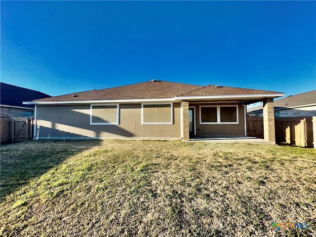 rear view of property featuring a yard and a patio