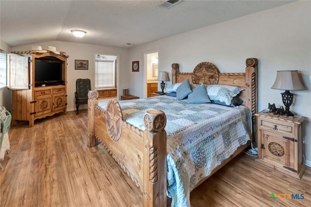 3662 N Fm 444, Inez, TX 77968 - bedroom with light wood finished floors, vaulted ceiling, a textured ceiling, and baseboards