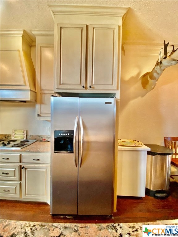 kitchen featuring light hardwood / wood-style floors, stainless steel refrigerator with ice dispenser, custom range hood, white cooktop, and cream cabinetry