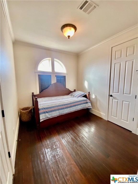 bedroom featuring dark wood-type flooring and ornamental molding