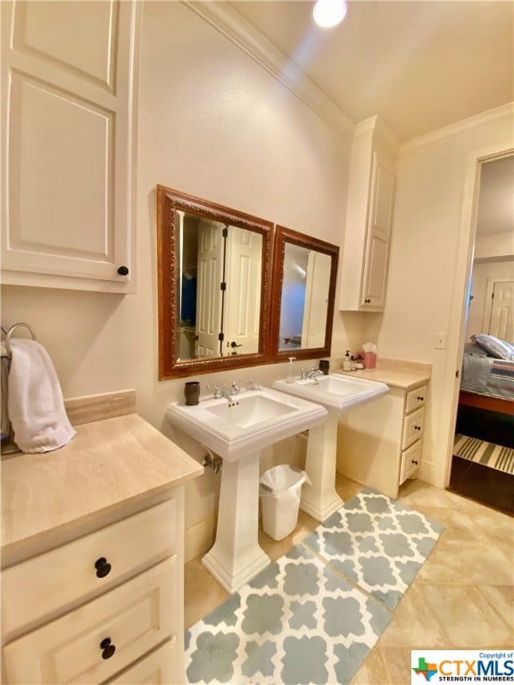 bathroom with double sink, tile patterned floors, and crown molding