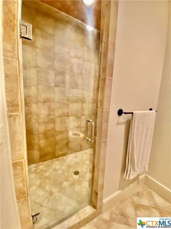 bathroom with a shower with door