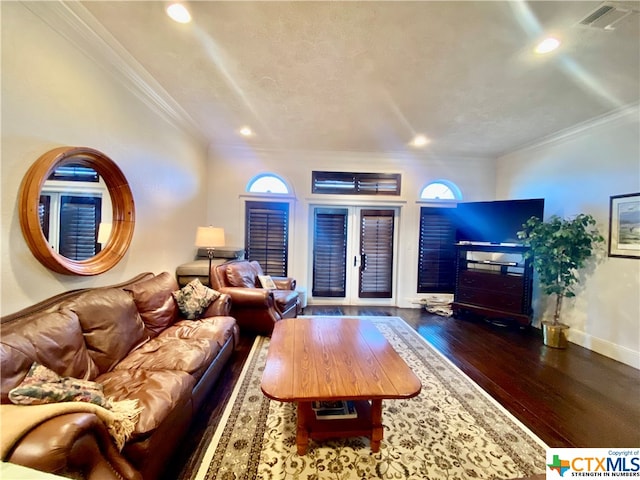 living room featuring dark hardwood / wood-style flooring, a textured ceiling, and crown molding