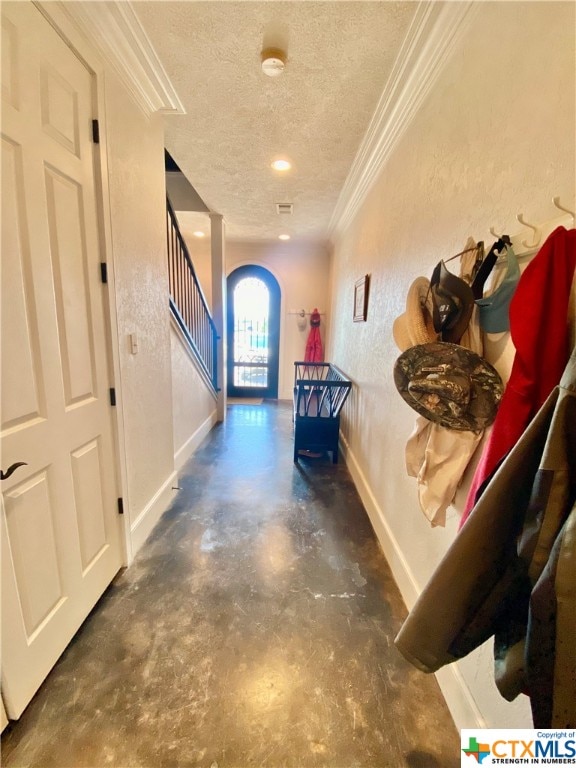 hallway featuring ornamental molding and a textured ceiling