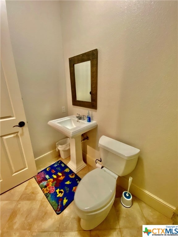 bathroom featuring toilet and tile patterned flooring