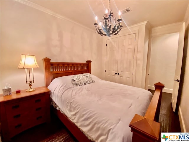 bedroom featuring a chandelier, crown molding, and a closet