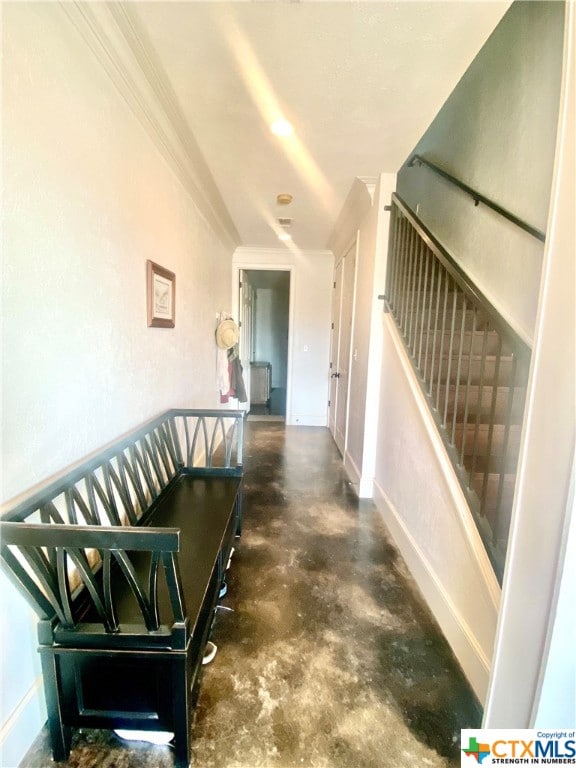 staircase with concrete flooring and crown molding