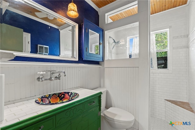 bathroom featuring toilet, wood ceiling, and tiled shower