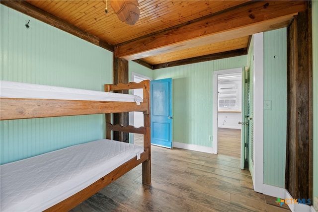 bedroom featuring wood ceiling, wooden walls, dark hardwood / wood-style floors, and beam ceiling