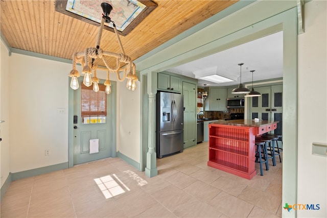 kitchen featuring a kitchen bar, green cabinetry, stainless steel appliances, wood ceiling, and a skylight