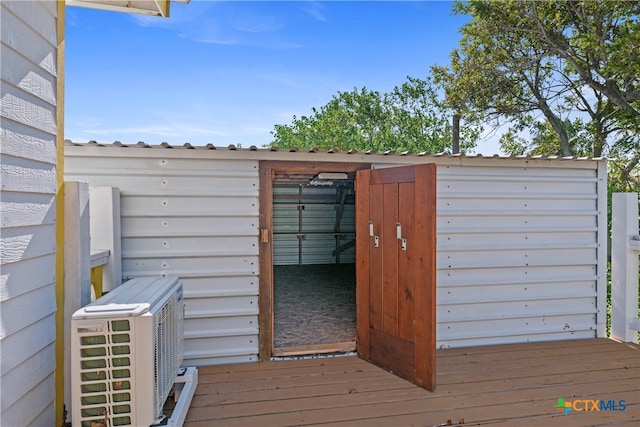 deck featuring a shed and ac unit