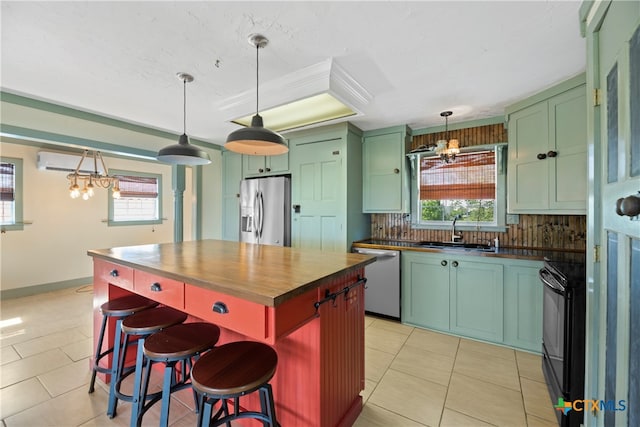 kitchen featuring sink, appliances with stainless steel finishes, a breakfast bar area, a healthy amount of sunlight, and decorative backsplash