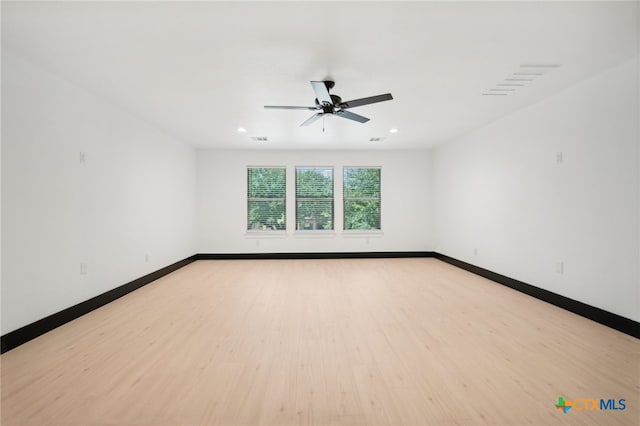 spare room featuring ceiling fan and light hardwood / wood-style floors