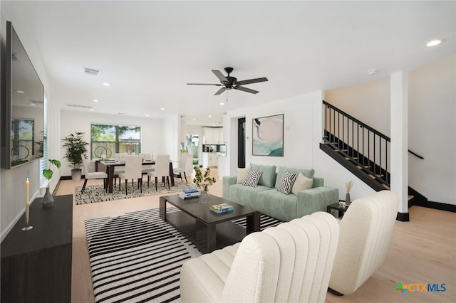 living room featuring light wood-type flooring and ceiling fan