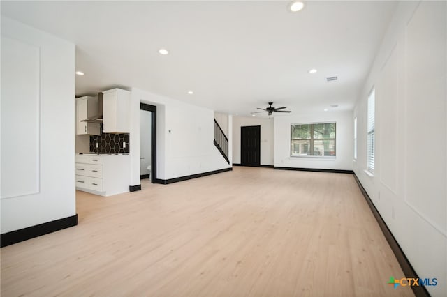 unfurnished living room with ceiling fan and light hardwood / wood-style floors