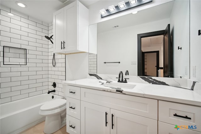 full bathroom with vanity, toilet, and tiled shower / bath