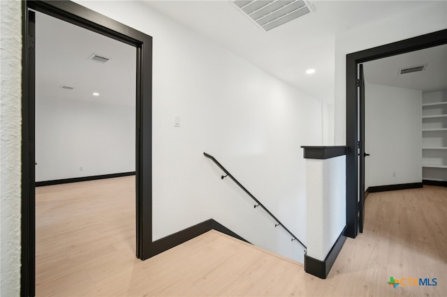 corridor with hardwood / wood-style flooring