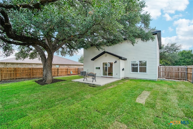 rear view of house featuring a yard, cooling unit, and a patio