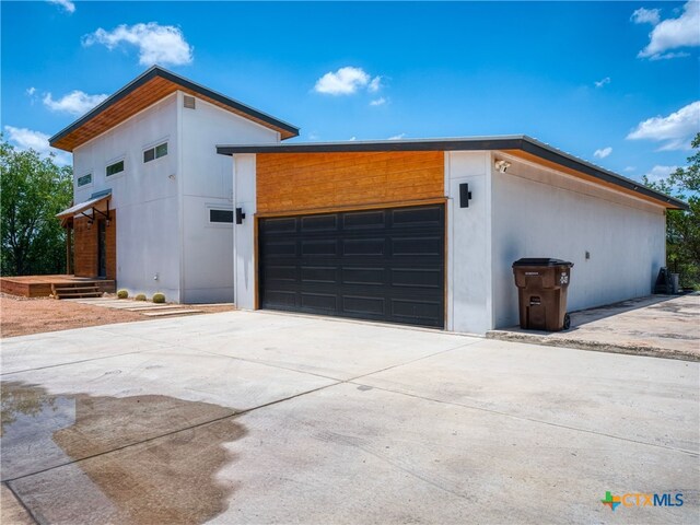 view of property exterior featuring driveway and a garage
