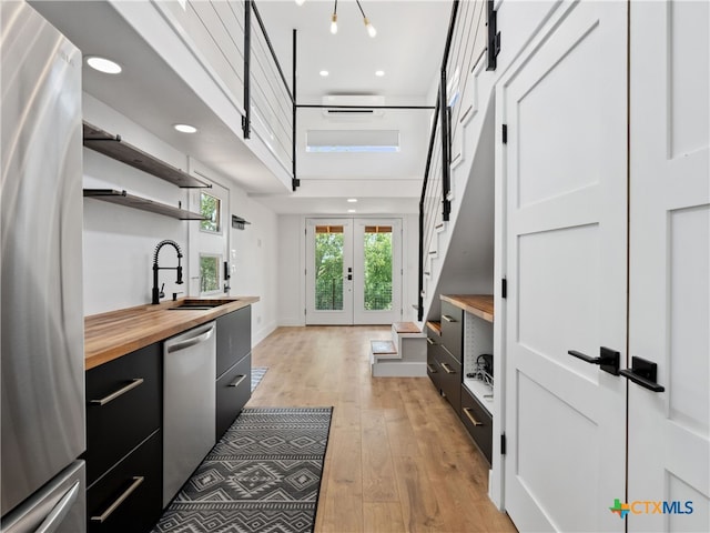 mudroom with recessed lighting, light wood-style floors, baseboards, and a sink